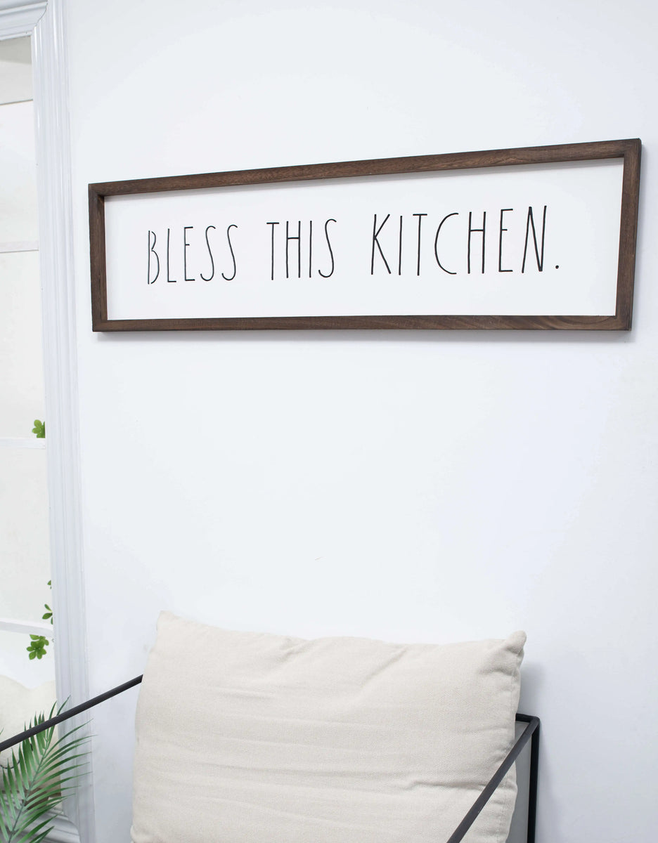 http://shopdesignstyles.com/cdn/shop/products/Rae-Dunn-kitchen-plaque-Bless-This-Kitchen-lifestyle-184402RD_1200x1200.webp?v=1678915104