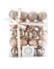 Load image into Gallery viewer, Front angle of the package with the silver tree balls. This package is made with a transparent plastic, permitting to see the ornaments within. It is adorned with a white ribbon that have gold-colored borders.
