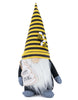 Load image into Gallery viewer, Front-angle picture of the spring bee-themed gnome. From this angle, the main features of the gnome can be fully appreciated: the white plush honey jar with the term &quot;Happy Spring&quot; on it, the honey dipper inside, the hat adorned with bee figurines, and its prominent white beard. The background of the picture is white.
