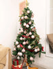 Load image into Gallery viewer, Lifestyle picture of the set of 50 light pink Christmas tree ornaments. The ornaments are hung on a Christmas tree. It can be appreciated that the 50 ornaments are enough to fully decorate the tree.
