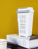 Load image into Gallery viewer, A lifestyle picture of the coffee-themed teacher décor. It is positioned at a frontal angle, but tilted to the right. The sign stands on a stack of two books: the upper one gray and the lower one purple. A yellow wall is visible behind the sign. In the frontal left part of the photo, a white mug can be seen.
