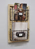 Load image into Gallery viewer, Lifestyle picture of the two-tier document organizer. Captured from a slight left perspective, the organizer is mounted against a gray-colored wall. The upper basket holds magazines, and its label holder displays a small paper marked “Magazines.” Files can be seen in the lower basket, and its label holder also contains a paper labeled “Files.” This serves as an example of how the organizer can be used.
