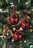 Load image into Gallery viewer, Lifestyle picture of the set of 4 gnome-themed tree ornaments. They are hanging on a Christmas tree with lighting bulbs. The light is reflected on the ornaments, giving it a shining effect.

