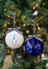 Load image into Gallery viewer, Lifestyle picture of the Blue and white Jewish related ornaments. The ornaments are hanging on a Christmas tree, and yellow lights from Christmas bulbs are shining on them.
