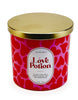 Load image into Gallery viewer, Front angle of the scented candle with romance-related fragrance. In this angle, all the features of the candle can be fully appreciated: The pink container adorned with a red-colored heart pattern, the white label showing the term &quot;Love Potion&quot; and its ingredients, and the golden color lid atop the jar. The background of the picture is white.
