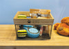 Load image into Gallery viewer, Lifestyle picture of the Rae Dunn basket designed for storing dog toys. Positioned at a frontal angle and placed on a wooden tabletop, the basket contains many toys inside. A bag of dog food is also visible. All these items serve as examples of the types of products this basket can hold.

