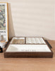 Load image into Gallery viewer, Lifestyle picture of the wood tray with compartments for jewelry. The tray is placed on a wooden table and captured from a slightly elevated angle. A beige wall intersects the table near the tray.

