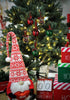 Load image into Gallery viewer, Second lifestyle picture of the Christmas ornaments. They are hanging on a Christmas tree with lighting bulbs on it. In front of the tree, there&#39;s a red and white Christmas gnome that holds a red decorative heart. There are also three decorative red, white, and green Christmas boxes on the right side, one above the other. Next to the boxes, there&#39;s a decorative calendar with the term &quot;Days &#39;Till Christmas&quot; on it.
