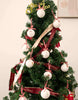 Load image into Gallery viewer, Second lifestyle picture of the set of twelve ornaments. This picture captures a Christmas tree, spanning from the bottom to near the highest top part.  The twelve ornaments are hanging on this tree, which is also adorned with a red and gold garland. The ornaments are evenly distributed on the front section of this tree.
