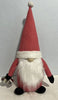Load image into Gallery viewer, Lifestyle picture of the Santa Gnome for Christmas décor. It is placed on a white surface, in front of a gray wall. The gnome is standing in a frontal angle.
