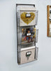 Load image into Gallery viewer, Lifestyle picture of the file holder, captured from a slight left angle and placed against a gray wall. It contains paper-based items in each compartment. The top compartment displays the label holder with the label &quot;Magazines,&quot; the middle one features the label &quot;Files,&quot; and the bottom one also has a &quot;Files&quot; label in its label holder. The picture serves as an example of the paper-based materials that can be stored in the compartments, also demonstrating how they can be categorized using the label holders.
